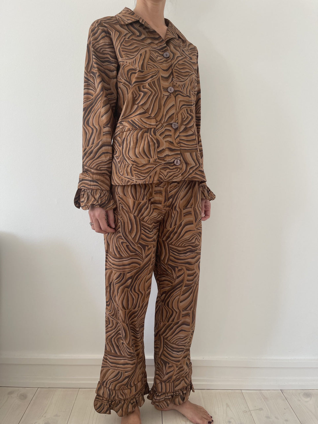 Helmstedt sæt med skjorte og bukser i brunt mønster på model fra side