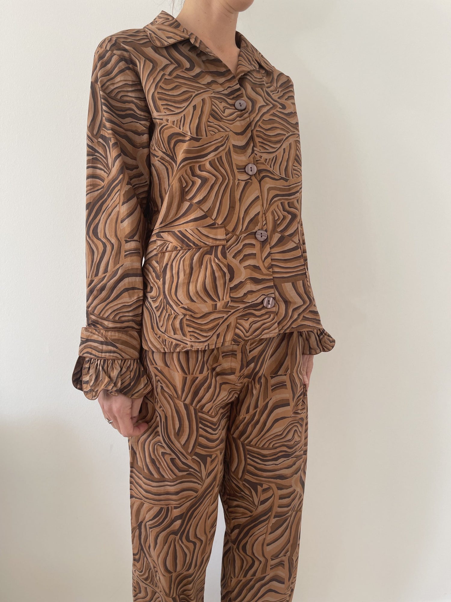 Helmstedt sæt med skjorte og bukser i brunt mønster på model side tæt på